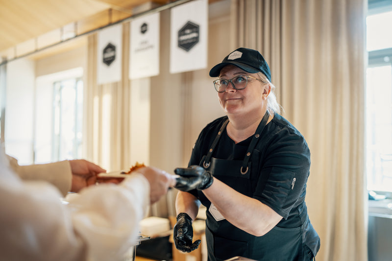 tarjoilija antaa asiakkaalle koemaistettavaa